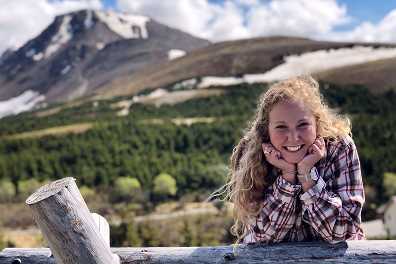 Women smiling in front of the Flattop mountain